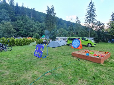 Piaskownica i kolorowe elementy placu zabaw na terenie obiektu