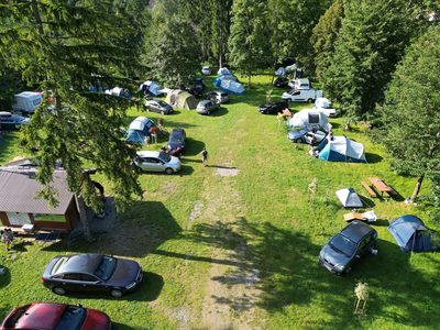 Widok z lotu ptaka na zielony teren obiektu Orłowa z namiotami, przyczepami i kamperami